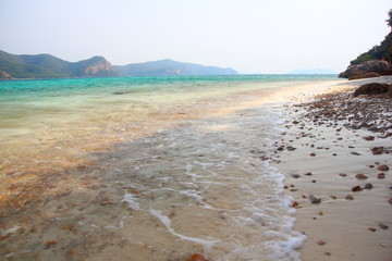 Beach and tropical sea, water clear,and have mountain on blue sky.Koh kham ,Pattaya Chonburi.