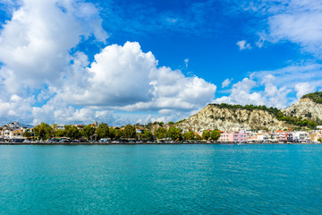 Naklejka premium Greece, Zakynthos, Zante city houses and hills behind blue water