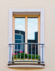 french style balcony windows with geranium flower pots, house facade detail