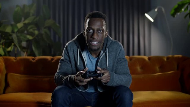 Determined male gamer feeling the various high and low emotional pressure  as he plays and competes in an intense online video game.