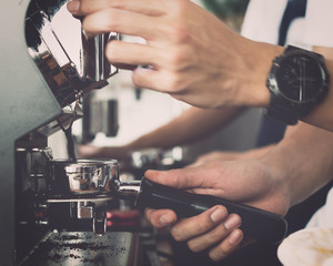 Man barista using coffee machine for making coffee.