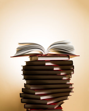 An open book on a stack of red books in the form of a spiral.