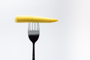 Mazorca de ma&iacute;z baby pinchada en un tenedor
