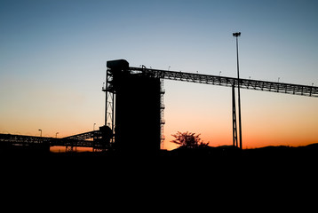 Silhouette of a mining silo and conveyor belts