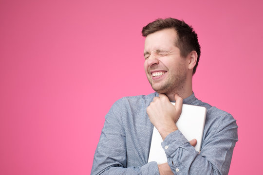 Happy Young Man Holding Tablet Standing Over Pink Wall