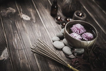Singing bowl with candles with pebbles on dark wooden background