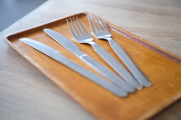 Fork and knife on a wooden plate.