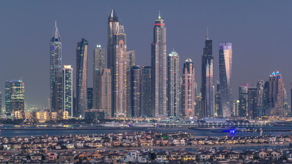 Dubai Marina skyline day to night timelapse as seen from atlantis on  Palm Jumeirah in Dubai, UAE.