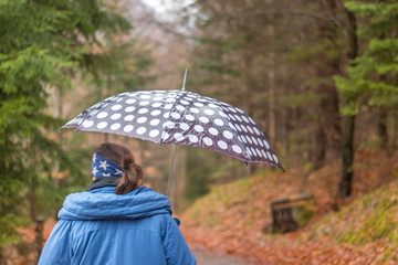 woman with umbrella in autumn park