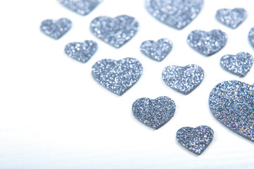 Valentine's Day, silver and red hearts on a white background with empty space