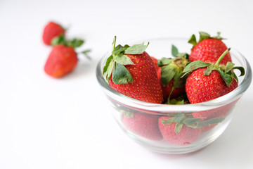 Fresh juicy strawberries with leaves placed on a white table
