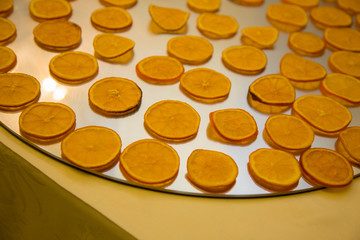 horizontal image with detail of thin slices of orange arranged neatly on a tray prepared for a party