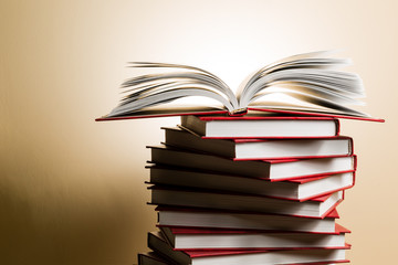 An open book on a stack of red books in the form of a spiral.