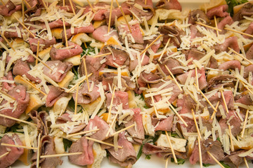 horizontal image with close detail of roast beef nuggets and cheese shavings a typical Italian appetizer