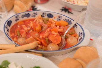 horizontal image with close up detail of salad with vegetables, carrots, onions, string beans, and tomato sauce