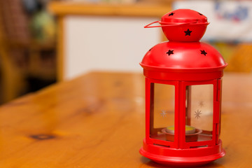 horizontal image with detail of a red Christmas lantern over a table