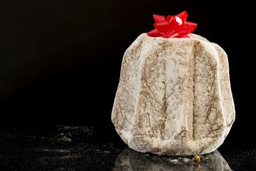 horizontal image with close detail of a typical italian Christmas cake, the pandoro with a black background