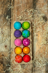 beautiful, bright, very colorful hand-painted eggs on a contrasting, raw, natural background from wooden planks