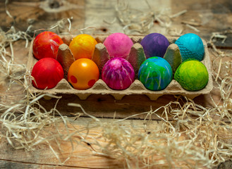beautiful, bright, very colorful hand-painted eggs on a contrasting, raw, natural background from wooden planks