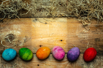 beautiful, bright, very colorful hand-painted eggs on a contrasting, raw, natural background from wooden planks