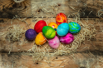 beautiful, bright, very colorful hand-painted eggs on a contrasting, raw, natural background from wooden planks