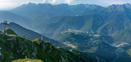 Naklejka premium Panoramic summer view from the top of the Aibga range to the Rosa Khutor ski resort. Krasnaya Polyana, Sochi, Caucasus, Russia.