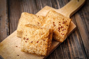 Healthy homemade pastry with integral flour and seeds on kitchen cutting board. Wooden table and rustic vintage background.