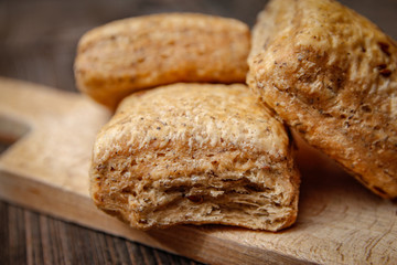 Healthy homemade pastry with integral flour and seeds on kitchen cutting board. Wooden table and rustic vintage background.