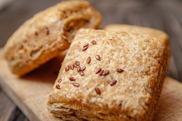 Healthy homemade pastry with integral flour and seeds on kitchen cutting board. Wooden table and rustic vintage background.