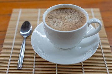 Hot coffee in a white cup on the table