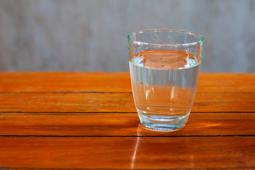 Drinking water in a glass on a wooden table