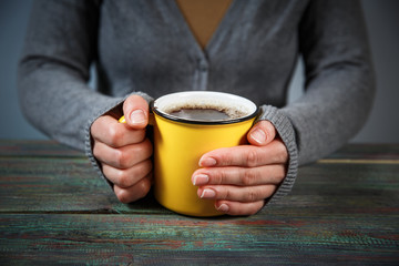 Woman holds a cup of hot tea. Cozy morning at home.