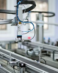 Gripper picks up the product from automated car which is on the manufacturing line in a smart factory. Industry 4.0 concept; artificial intelligence in manufacturing.