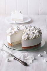 Angel's Food Cake with Vanilla Souffle and Meringue Cookies, on white wooden table.