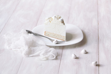 Angel's Food Cake with Vanilla Souffle and Meringue Cookies, on white wooden table.