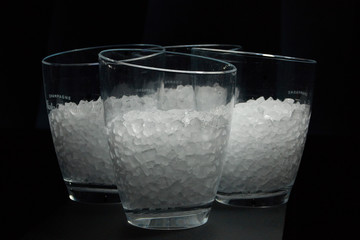 Steel ice bucket full with ice cubes from side view