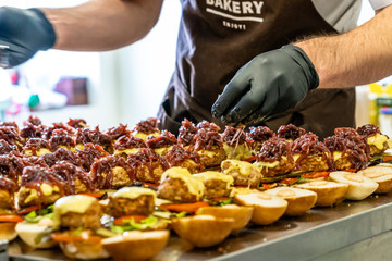 Odziena / Latvia - August 24th, 2018: Male Chef Putting Ingredients of Burgers in Black Gloves - Concept of the Hard Working Person and the Hygiene in the Kitchen, Partly Blurred Foreground
