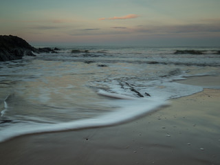 beaautiful waves rushing onto shore at Croyde Bay in Devon at sunrise
