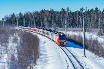 Naklejka premium Modern high-speed train approaches to the station at winter morning time.