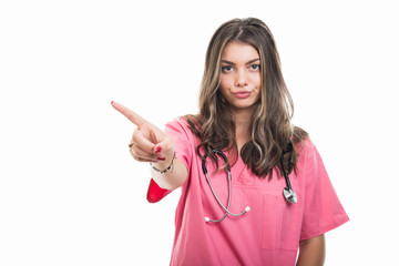 Portrait of beautiful young doctor wearing scrubs showing denial gesture