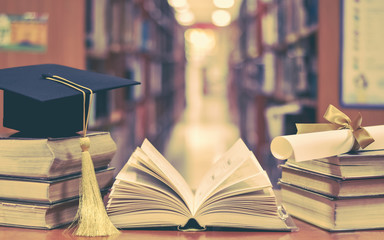 Education success with graduation hat, academic cap, mortarboard, and degree certificate on books and textbooks in class or library study room