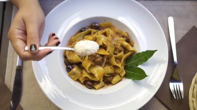 Slow Motion 120fps: Young Women Spreading Out Parmesan Cheese Over Pasta In Plate. Top Down View