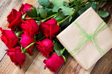 Mother day background or Valentines Day, wedding day. Beautiful blooming Red roses and present on wooden board. Top view flat lay background.