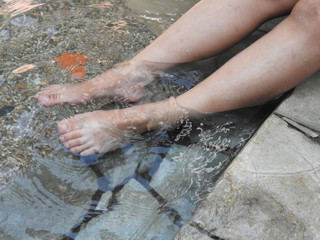 A pair of female legs are soaked in hot spring water, which can promote blood circulation and keep the body healthy. With copy space. Health care concept.