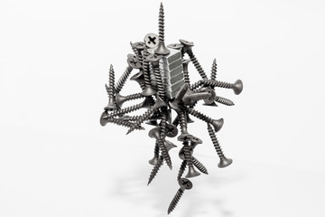 Abstract figurine of black self-tapping screws hanging on the magnet