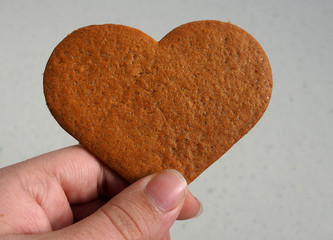 Galleta con forma de coraz&oacute;n cogida por una persona