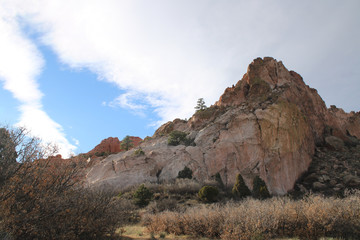 rocky mountain with scrub bushes and blue sky