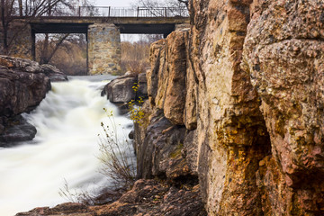 Late autumn photo of old stone bridge over mountain river tourism and recreation