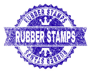 RUBBER STAMPS rosette stamp seal watermark with grunge style. Designed with round rosette, ribbon and small crowns. Blue vector rubber watermark of RUBBER STAMPS title with grunge texture.