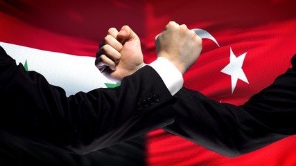 Syria vs Turkey confrontation, countries disagreement, fists on flag background